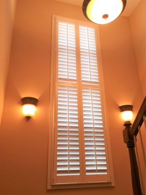 Polywood plantation shutters in brightly lit stairwell.